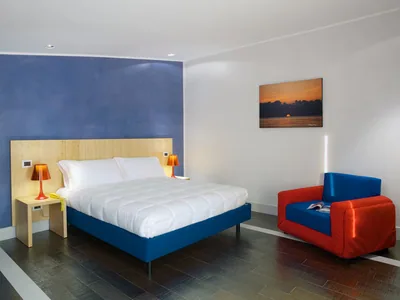 A room at Hotel Intervallo with a double bed and armchair